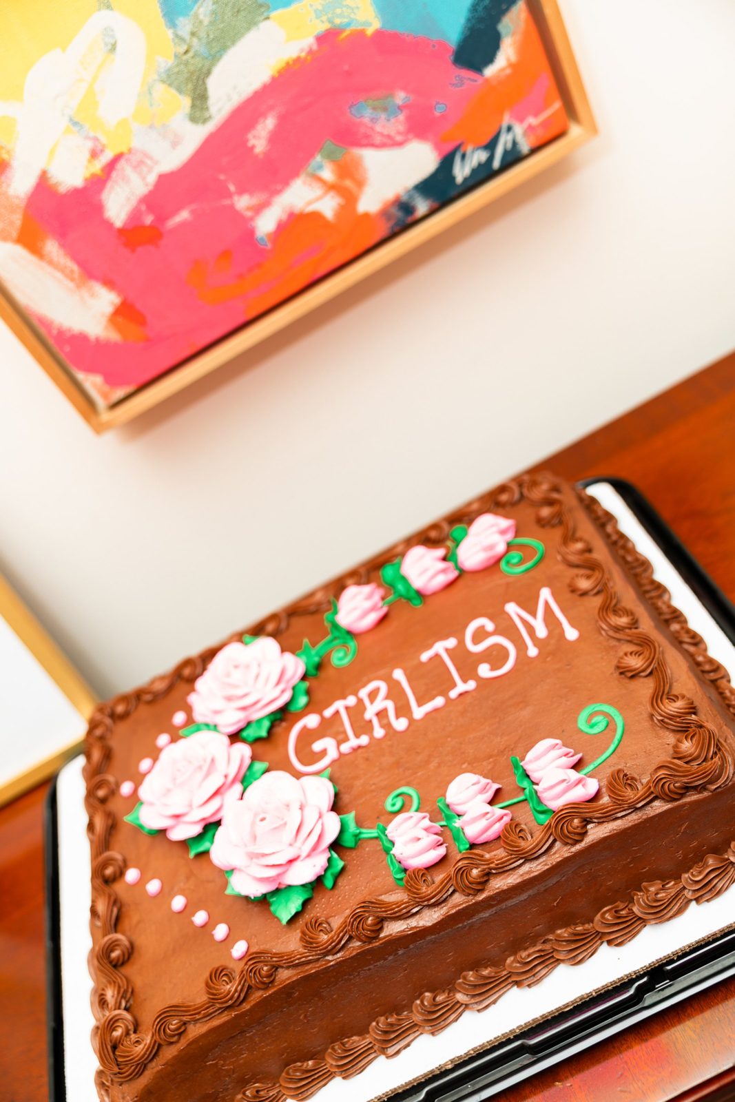 A sheet cake iced with the word Girlism