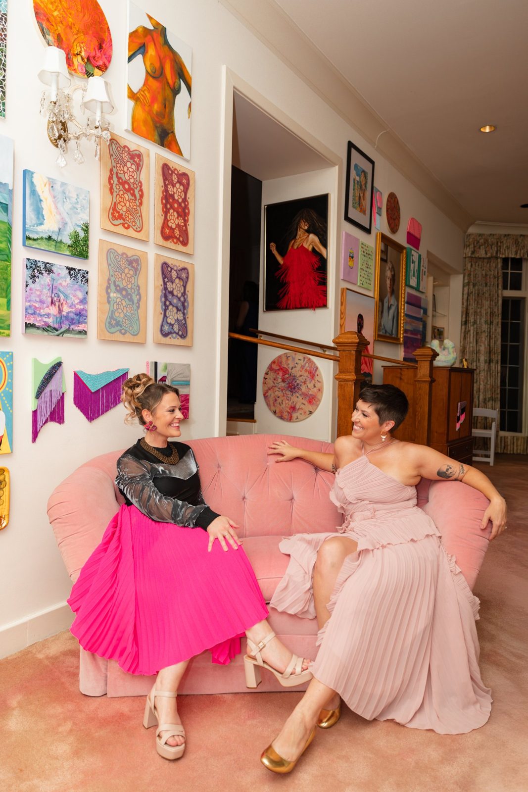 Sarah Jamison and Stephanie Ervin, co-founders, laughing on the pink sofa at the Girlism gala