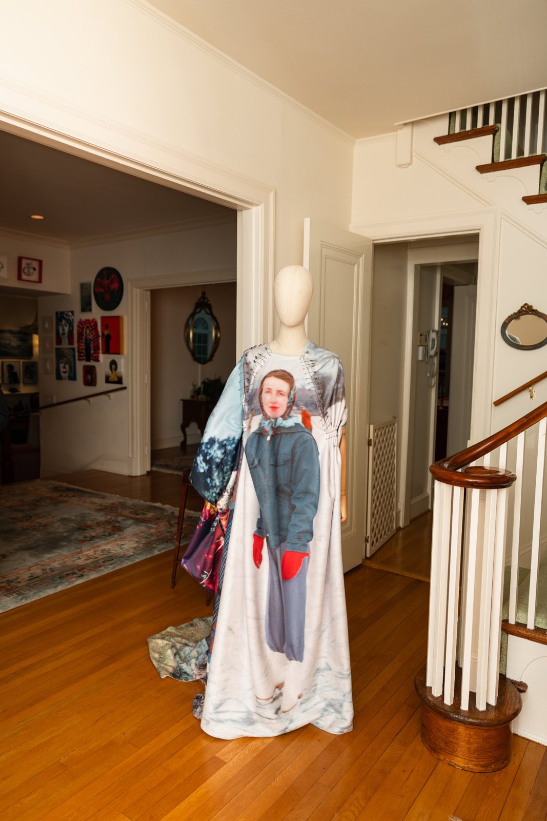 The entry hall and staircase at Girlism with a dressed mannequin sculpture